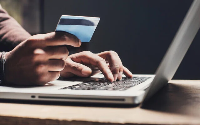 Illustrative image of a person entering payment-card information on a laptop