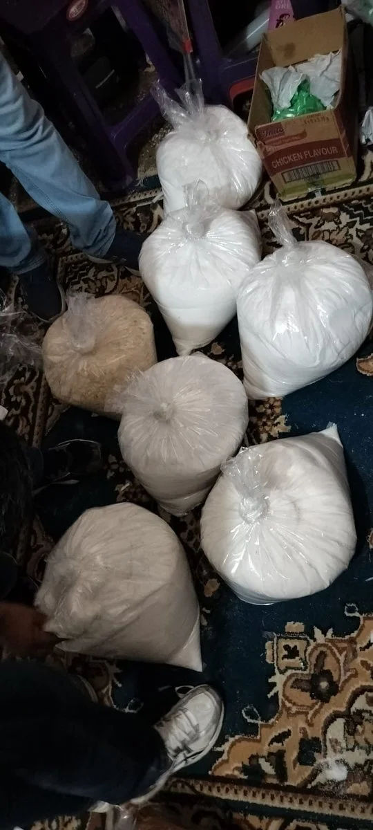 Multiple bags of suspected seized substances displayed indoors